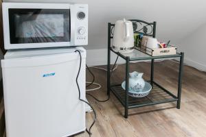 a microwave oven sitting on top of a refrigerator at Les rayonnantes in La Roche-Maurice