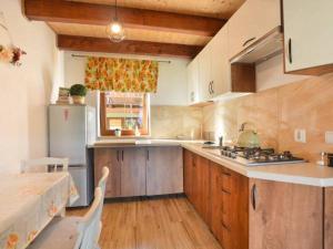 a kitchen with wooden cabinets and a white refrigerator at Domki U Tadzia 603-425-844 in Polańczyk