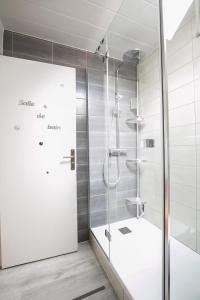 a shower with a glass door in a bathroom at Les rayonnantes in La Roche-Maurice