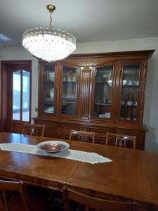 a dining room with a wooden table and a chandelier at Francelos Village in Vila Nova de Gaia