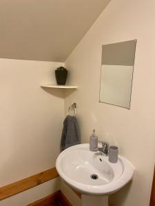 La salle de bains est pourvue d'un lavabo et d'un miroir. dans l'établissement Holmview apartment, à Stornoway