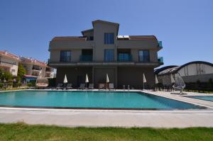 a building with a swimming pool in front of a building at Mykonut Erna Apart Hotel in Fethiye