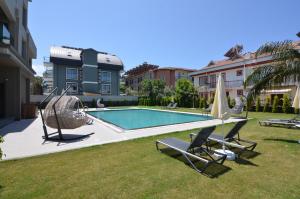 uma piscina com duas cadeiras e um guarda-sol e um sidx sidx sidx sidx em Mykonut Erna Apart Hotel em Fethiye