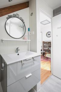 a bathroom with a sink and a mirror on the wall at Les rayonnantes in La Roche-Maurice