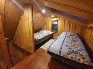 - une chambre avec 2 lits dans une cabane en bois dans l'établissement U Jana, à Zwierzyniec