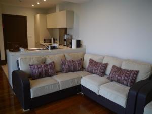 a living room with a couch and a kitchen at Liver View Apartments in Liverpool