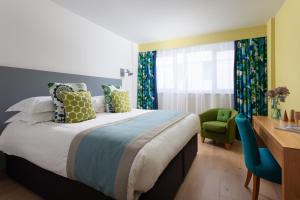 
a bedroom with a bed, a chair, and a window at Bedruthan Hotel & Spa in Newquay
