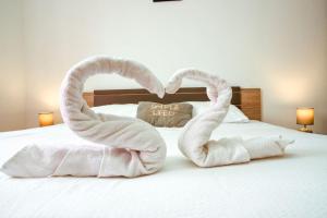 two towels shaped like swans sitting on a bed at Apartment Goli in Komiža +27 photos
