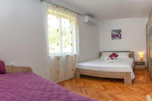 a bedroom with two beds and a window at Apartment Goli in Komiža