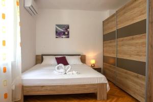 a bedroom with a bed with two white towels on it at Apartment Goli in Komiža