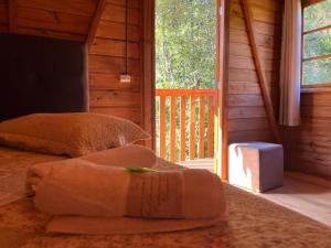 En eller flere senge i et værelse på chalés Sítio Anjo Gabriel