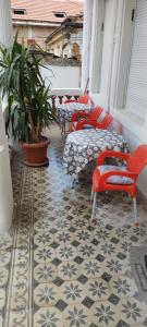 a balcony with red chairs and tables on a floor at Guest House Prilep in Prilep