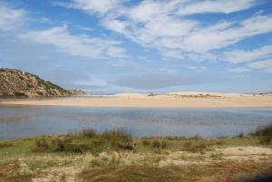 a beach with a body of water and a sandy beach at Casa Lusco Fusco in Carrapateira