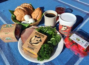 a table with a plate of food with eggs meat and vegetables at Glamping Kotitila Kiveinen in Laitila