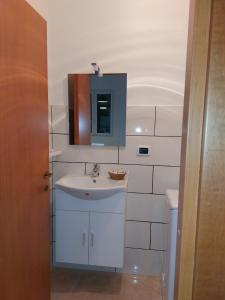 a white bathroom with a sink and a mirror at Esther Guest House in Castel Volturno