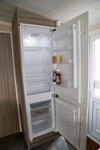 un réfrigérateur vide avec une porte ouverte dans une pièce dans l'établissement Silver Birch Retreat - Percy Woods Country Retreat With 18 HOLE FREE GOLF, à Alnwick