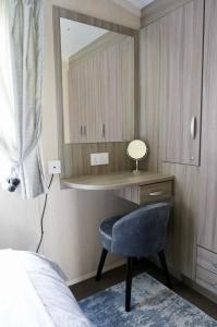 1 dormitorio con escritorio, silla y espejo en Silver Birch Retreat - Percy Woods Country Retreat With 18 HOLE FREE GOLF, en Alnwick