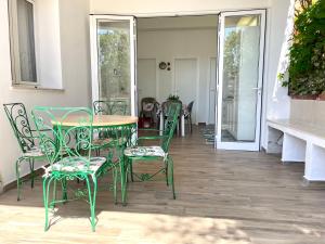 a green table and chairs on a patio at Casa Safari in Marzamemi +21 photos