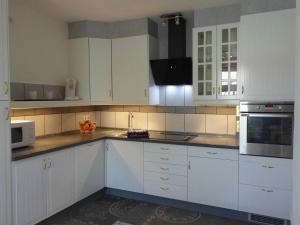 a kitchen with white cabinets and white appliances at Ferienwohnung Ruhepunkt in Halver