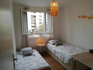 two beds in a room with two windows at Résidence du Parc fleuri de Lyon Cœur Lyon8 PKG free 95m2 in Lyon
