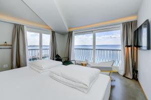 um quarto com 2 camas brancas e uma grande janela em Hotel Flaminia em Sirmione