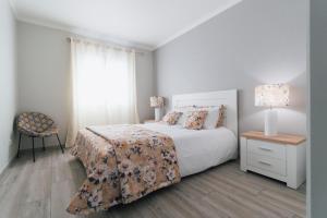 Un dormitorio con una cama y una mesa y una ventana. en Quintas do Mar, en Ribeira Grande