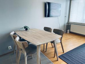 a wooden table with chairs in a room at Ruoholahti Apartment with private sauna in Helsinki