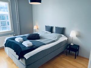 a bedroom with a bed with two pillows on it at Ruoholahti Apartment with private sauna in Helsinki