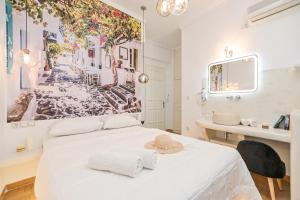 ein Schlafzimmer mit einem weißen Bett mit Hut darauf in der Unterkunft Katy's Home in Naxos Chora