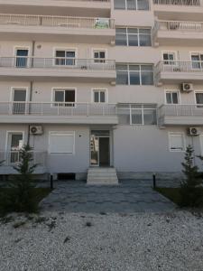 a large white building with a balcony at R&I Sea and Mountain View Apartments Radhimë in Orikum
