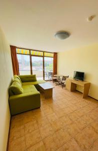 sala de estar con sofá verde y mesa en Kaya Apartments, en Sunny Beach