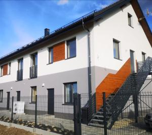 a white house with a staircase in front of it at Apartamenty Stołowe in Kudowa-Zdrój