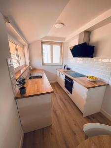 穆羅斯的住宿－Dania Home Esteiro，厨房配有白色橱柜和台面