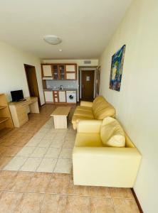 ein Wohnzimmer mit Sofa und eine Küche in der Unterkunft Kaya Apartments in Sonnenstrand