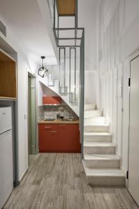 a staircase in a kitchen with a red cabinet at GreyStone Suites in Paralia Dionysiou