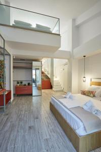 a bedroom with a large bed and a staircase at GreyStone Suites in Paralia Dionysiou