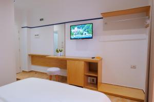 a hotel room with a television and a bed at Hotel Piccolino in Sarandë
