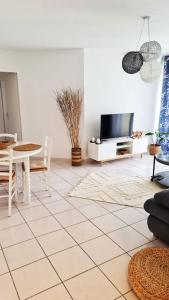 a living room with a tv and a tiled floor at Appartement 63 m2, tout confort, climatisé. in Saint-Cyprien