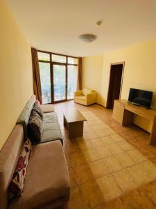 ein Wohnzimmer mit Sofa und Fernseher in der Unterkunft Kaya Apartments in Sonnenstrand