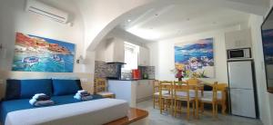 カマリにあるChariot Apartments Santoriniのベッドルーム1室(ベッド1台付)、キッチン(テーブル付)