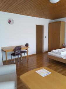 a living room with a table and a bed at Haus Hopp - Bungalow in Dahme