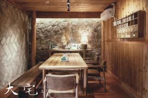 - une salle à manger avec une table et des chaises en bois dans l'établissement 大宅三院青年旅舍 背包客棧, à Beigan
