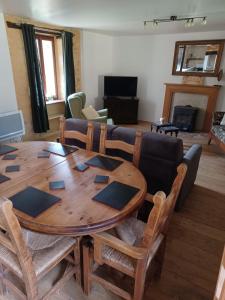 salon z drewnianym stołem i kanapą w obiekcie Gîtes Le clos de Veyrignac w mieście Veyrignac