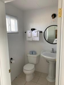 a white bathroom with a toilet and a sink at Grand View Hotel in York Beach