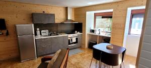 eine Küche mit einem Kühlschrank und einem Tisch im Zimmer in der Unterkunft Casa do Quinteiro in Arcos de Valdevez