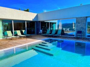 a swimming pool with chairs and a house at Oak Nature in Vieira do Minho