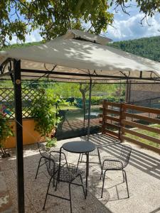 stół i krzesła pod parasolem na patio w obiekcie B&B Ollyfarm w mieście Fabriano