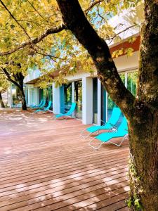 deux chaises bleues assises sur une terrasse à côté d'un bâtiment dans l'établissement Oak Nature, à Vieira do Minho