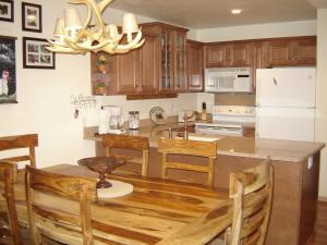 a kitchen with wooden cabinets and a table with chairs at Summit Ski Resort 2BR-2BA, Mammoth Lakes in Mammoth Lakes