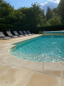 a swimming pool with chaises and chairs in a yard at Veyrinas 43 in Saint-Yrieix-la-Perche
